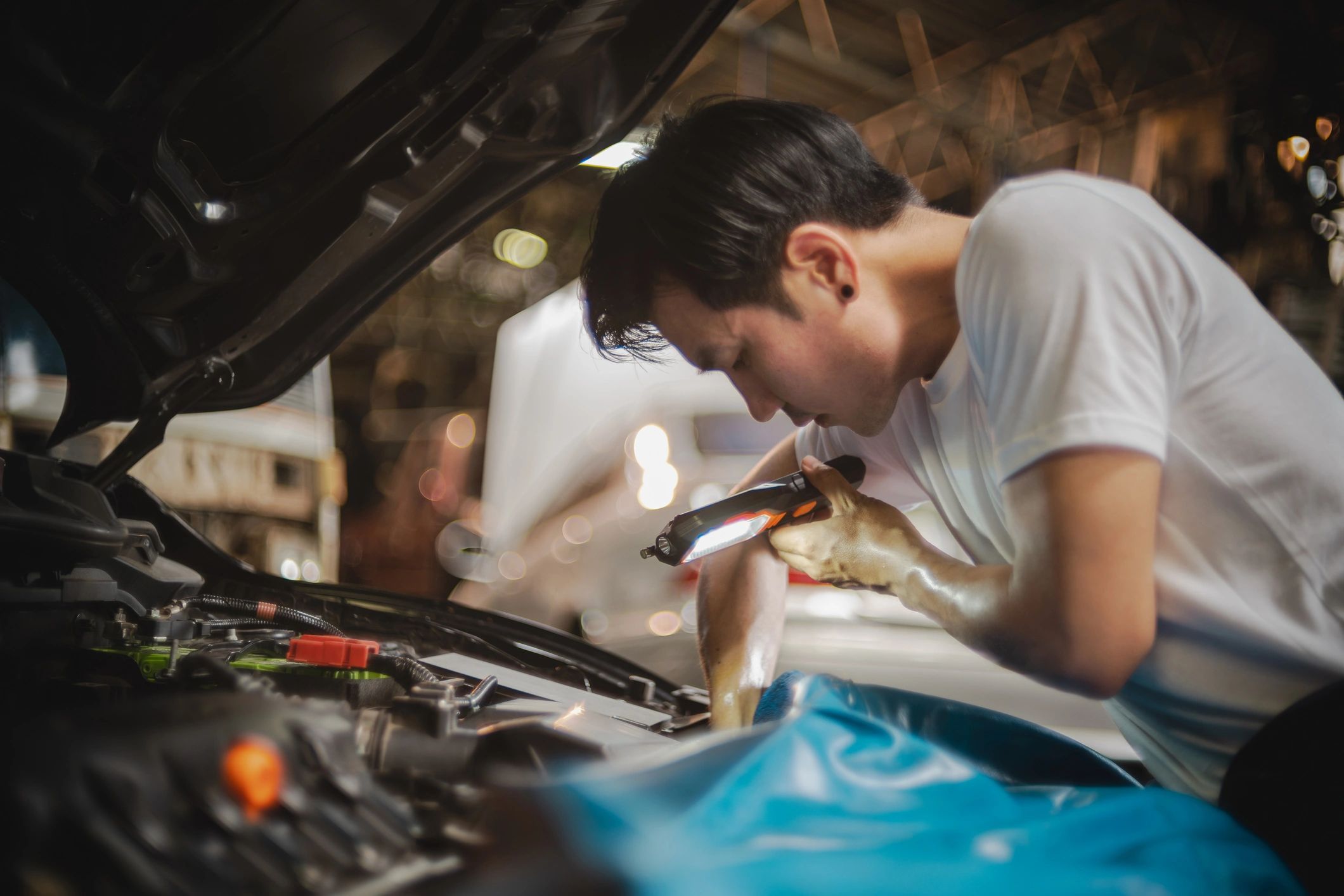 Mechanic inspecting a car engine during a vehicle check