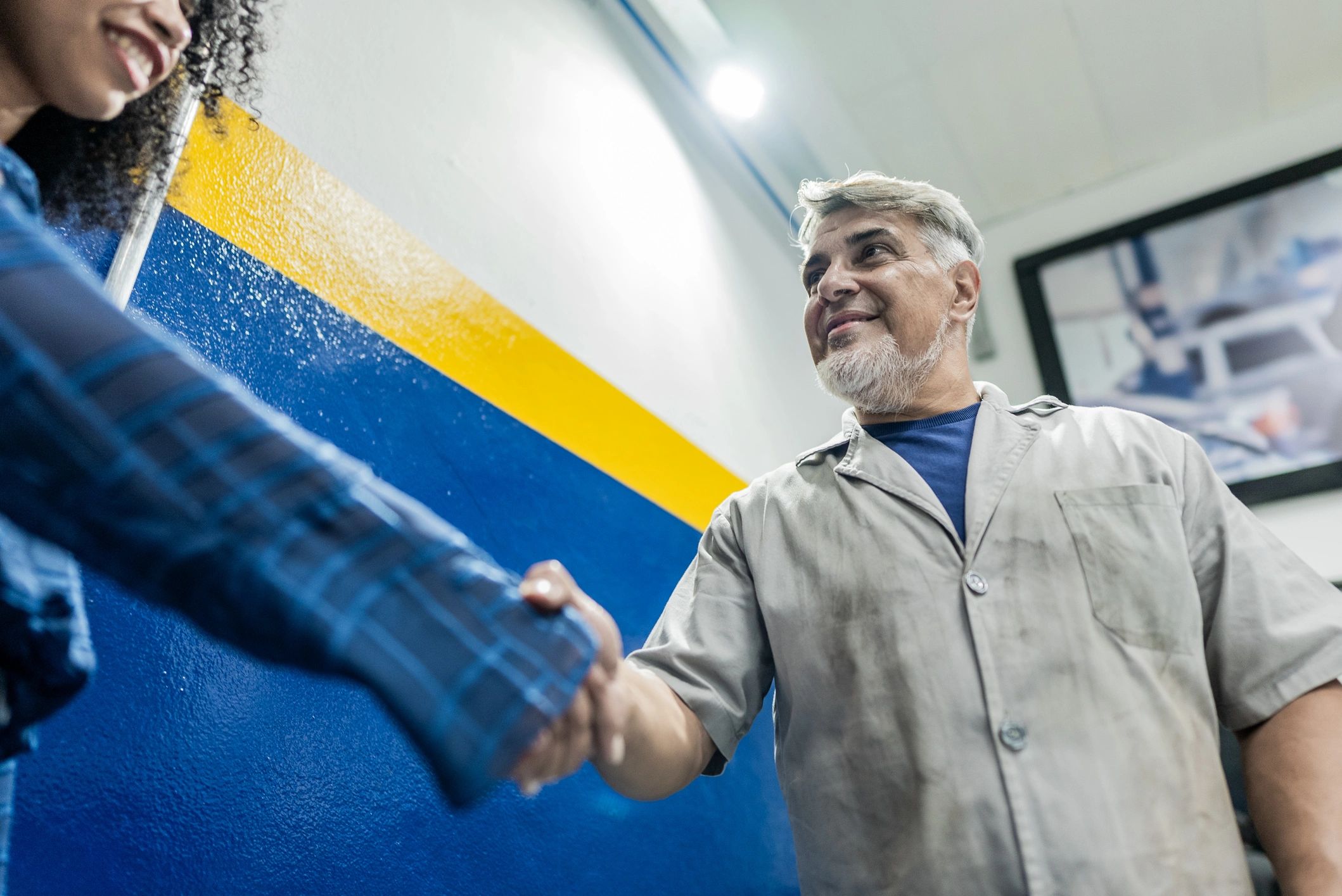 Mechanic greeting a customer at a garage